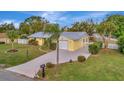 Attractive yellow house with gray metal roof, driveway, and landscaped yard at 409 Archibald Ave, Sarasota, FL 34243