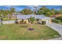 Cute yellow house with gray metal roof, white fence, and spacious lawn at 409 Archibald Ave, Sarasota, FL 34243