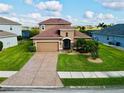 Two-story house with tan exterior, brown roof, and a two-car garage at 7926 111Th E Ter, Parrish, FL 34219