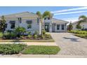 Gray house with a three-car garage and palm trees at 8372 Sea Glass Ct, Sarasota, FL 34240