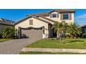 Two-story home with paver driveway, landscaping, and attached garage at 15511 Islandwalk Ave, Bradenton, FL 34211