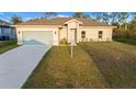 Newly built home with a light-colored exterior, two-car garage, and a grassy lawn at 2842 Escambia Cir, North Port, FL 34288