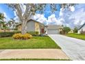 Mid-century modern home with gray exterior and mature tree at 6609 Waterford Ln, Sarasota, FL 34238