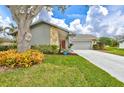 Mid-century modern home with gray exterior and mature tree at 6609 Waterford Ln, Sarasota, FL 34238