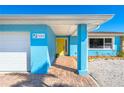 Exterior of waterfront home with bright blue walls and yellow door at 725 N Manasota Key Rd # A, Englewood, FL 34223