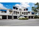 Modern condo building with blue awnings and attached garages at 1912 Harbourside Dr # 603, Longboat Key, FL 34228