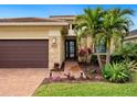 Landscaped front yard with palm trees and brick walkway at 4925 Surfside Cir, Bradenton, FL 34211