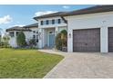 Two-story home with light-colored siding, a three-car garage, and a landscaped yard at 609 Colonial Bay Dr, Nokomis, FL 34275