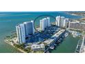 Aerial view of a waterfront highrise condo building with tennis courts at 988 Blvd Of The Arts # 915, Sarasota, FL 34236