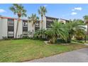 Condo building exterior with palm trees and well-maintained landscaping at 3213 Beneva Rd # 201, Sarasota, FL 34232