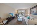 Bright living room featuring comfortable seating, a TV, and access to a balcony at 3213 Beneva Rd # 201, Sarasota, FL 34232