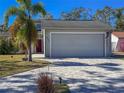 Home's exterior showcasing a two-car garage and a paved driveway at 8224 Country Oaks Ct, Sarasota, FL 34243