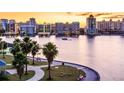 Scenic waterfront view with palm trees, a walkway, and city skyline at sunset at 2321 Hillview St, Sarasota, FL 34239