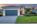 Modern house exterior with gray garage door and landscaping at 4939 Surfside Cir, Bradenton, FL 34211