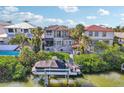 Stunning waterfront home featuring a private boat dock, lush tropical landscaping, and backyard tiki bar at 5159 Oxford Dr, Sarasota, FL 34242