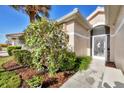Welcoming front entrance with lush landscaping and a decorative screen door at 8472 Gateway Ct, Englewood, FL 34224