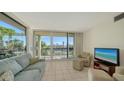 Living room with large windows, offering a view of the golf course at 1065 Gulf Of Mexico Dr # 201, Longboat Key, FL 34228