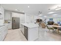 Open kitchen with island, stainless steel appliances, and views into Gathering room at 11907 Petunia Ter, Bradenton, FL 34212