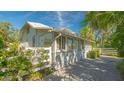 White house with sunlit side yard, showing a white picket fence and landscaping at 2525 Ashton Rd, Sarasota, FL 34231