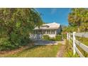Home exterior showcasing a white house with a fenced yard and lush greenery at 2525 Ashton Rd, Sarasota, FL 34231