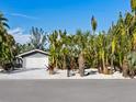 Gray house with white garage door and tropical landscaping at 671 Emerald Harbor Dr, Longboat Key, FL 34228