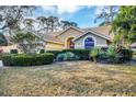 Tan two-story house with a red door and lush landscaping at 4882 Tivoli Ave, Sarasota, FL 34235