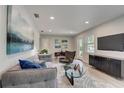 Modern living room with gray couch, glass coffee table, and large TV at 730 40Th St, Sarasota, FL 34234