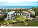 Aerial view of condo community with tennis courts and bay access at 8701 Midnight Pass Rd # 106A, Sarasota, FL 34242