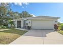Front view of single-story house with light-grey exterior and two-car garage at 8755 Dolomite Ave, North Port, FL 34287