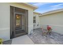 Front entry with a screened-in door and a sitting area with stone-like tile at 8755 Dolomite Ave, North Port, FL 34287