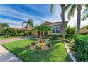 House with a well-manicured lawn, palm trees, and a brick paved driveway at 8912 Heritage Sound Dr, Bradenton, FL 34212