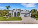 Single-story home with gray siding, tile roof, and a 3-car garage at 15808 42Nd E Gln, Parrish, FL 34219