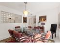 Modern glass dining table with red chairs in a bright dining area at 1704 Pelican Cove Rd # T138, Sarasota, FL 34231