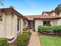Tan villa with brown tile roof and gated entryway at 7323 Oak Moss Dr # 42, Sarasota, FL 34241