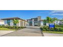 Modern home with a stone facade, two-car garage, and manicured landscaping at 1206 Blue Shell Loop, Sarasota, FL 34240