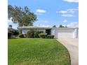 Charming single-story home with manicured lawn, mature tree, and attached garage on a sunny day at 1348 Westport Ln # 1405, Sarasota, FL 34232