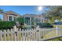 Two-story house with white picket fence, palm trees, and sunlit facade at 1714 Irving St, Sarasota, FL 34236