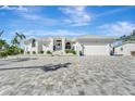 Modern white house with a gray paver driveway and attached garage at 2287 Bayshore Rd, Nokomis, FL 34275