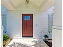 Red front door with white columns and shutters at 606 19Th W Ave, Palmetto, FL 34221