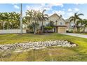 Two-story house with beige siding, gray door, and landscaped yard with rock drainage at 7000 Marina Dr, Holmes Beach, FL 34217