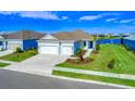 Single-story home with a two-car garage, and a landscaped yard at 14316 Skipping Stone Loop, Parrish, FL 34219