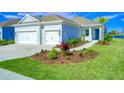 Two-car garage, front walkway, and nicely landscaped yard at 14316 Skipping Stone Loop, Parrish, FL 34219