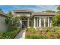 Inviting entryway with lush landscaping and columns at 1965 White Feather Ln, Nokomis, FL 34275