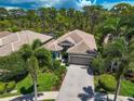 Single-story home with tile roof, paver driveway, and lush landscaping at 293 Turquoise Ln, Osprey, FL 34229