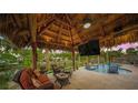 Relaxing poolside patio with thatched roof and comfortable seating at 4817 Ocean Blvd, Sarasota, FL 34242