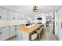 Modern kitchen with gray cabinets, a large island, and stainless steel appliances at 1007 Gulf N Dr # 106, Bradenton Beach, FL 34217
