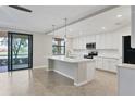 Modern kitchen with white cabinets, stainless steel appliances, and an island at 10796 Tarflower Dr # 102, Venice, FL 34293