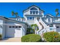 Two-story home with white garage doors and a well-maintained front yard at 1341 Siesta Bayside Dr # 1341-B, Sarasota, FL 34242