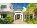 Curved white stucco home with double doors and lush landscaping at 269 Pine Ranch Trl, Osprey, FL 34229
