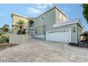 Two-story house with a light green exterior, white garage door, and paved driveway at 3408 Fair Oaks Ln, Longboat Key, FL 34228